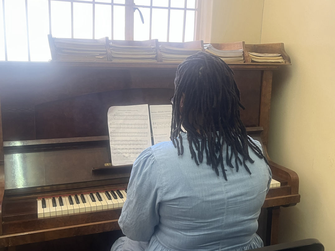 A student learning piano at Outreach Foundation